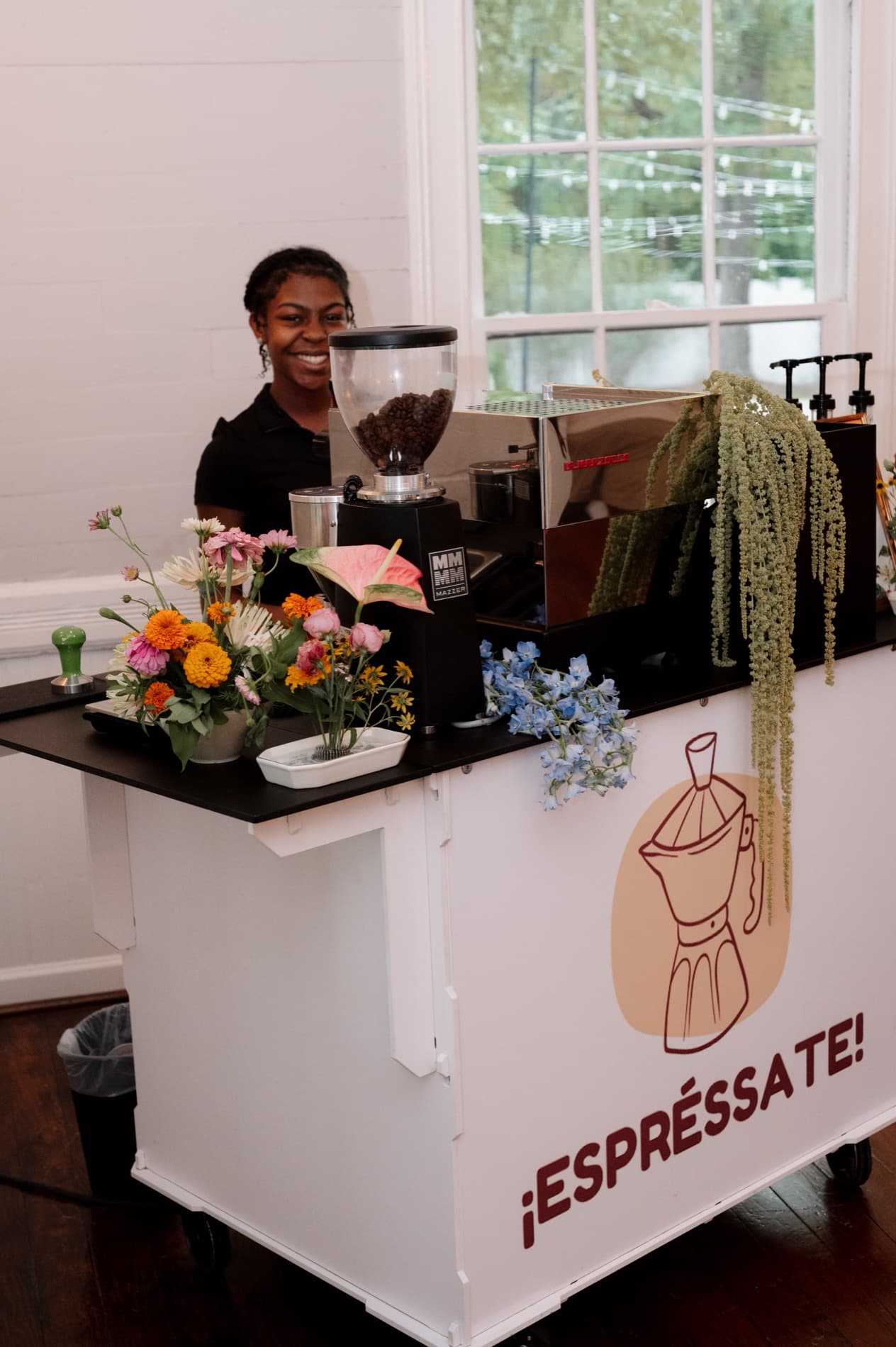 Espréssate barista smiling behind the branded mobile espresso bar at a Durham, NC event venue